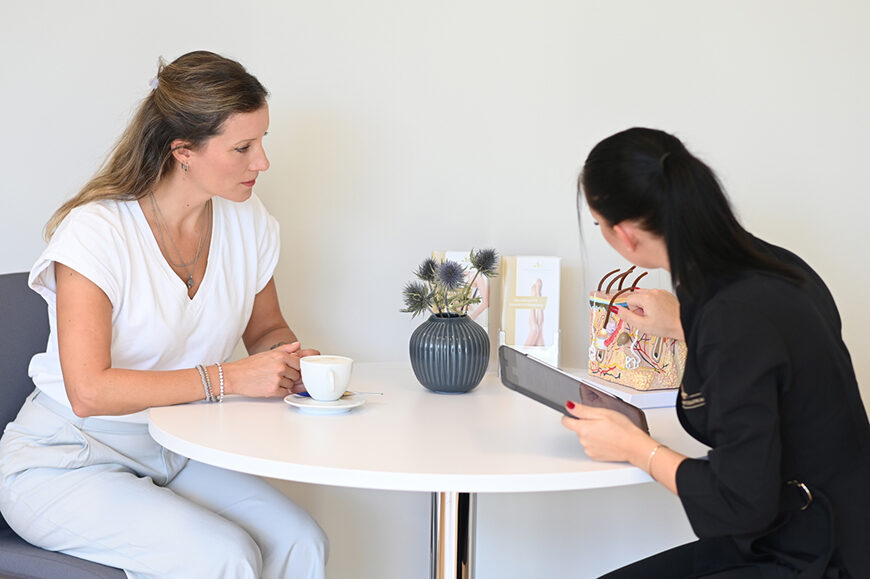 schoenheitszentrum-beratung-behandlung Beratungsgespräch in einer ästhetischen Praxis: Eine Fachkraft erklärt einer Patientin mithilfe eines anatomischen Modells und eines Tablets mögliche Behandlungsoptionen.